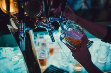 Barmen bardaki bardağa taze bira dolduruyor..