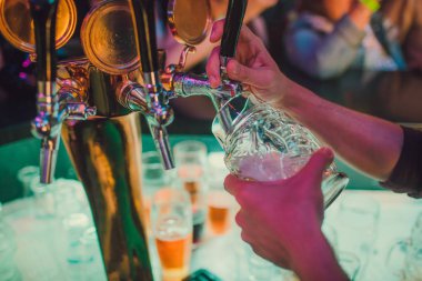 Barmen bardaki bardağa taze bira dolduruyor..