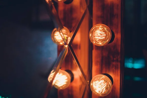 Dekorativa antika Edison stil ljus volfram lampor mot tegel vägg bakgrund. — Stockfoto