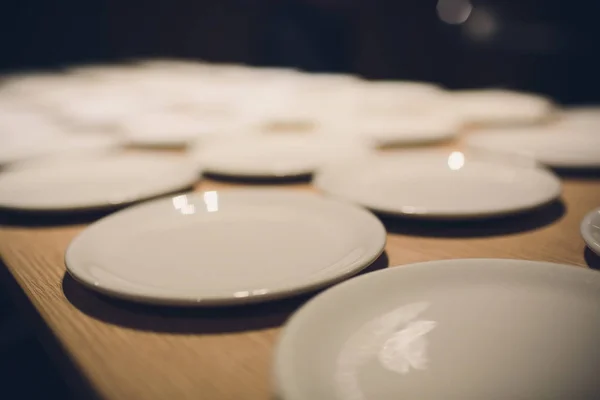 Muitos pratos brancos vazios na mesa . — Fotografia de Stock