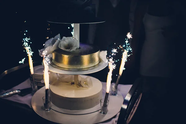 The wedding cake with fireworks stand on the table in restaurant. — Stock Photo, Image