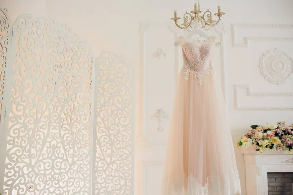 Свадебное платье висит на блеске в номере отеля . — стоковое фото