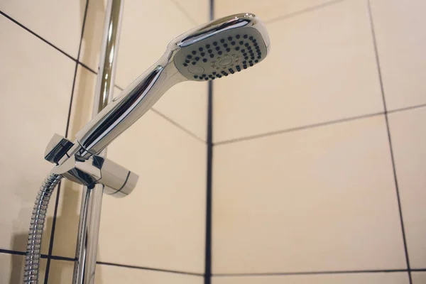 Agua corriente desde el cabezal de ducha en el baño con fondo negro oscuro. Diseño interior de hogar escandinavo simple, elegante y moderno . —  Fotos de Stock