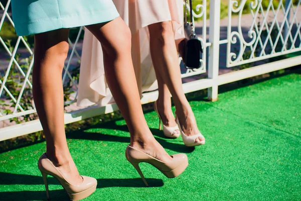 Hands and feet girls in heels, girls lifted their right leg — Stock Photo, Image