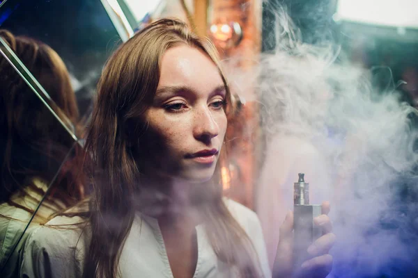 Genç kadın sigara elektronik sigara arka plan ayna karşı