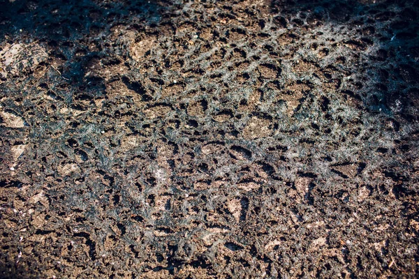 Staré přírodního kamene pokrytý černým lišejníků a mechu. Nádherný kámen — Stock fotografie