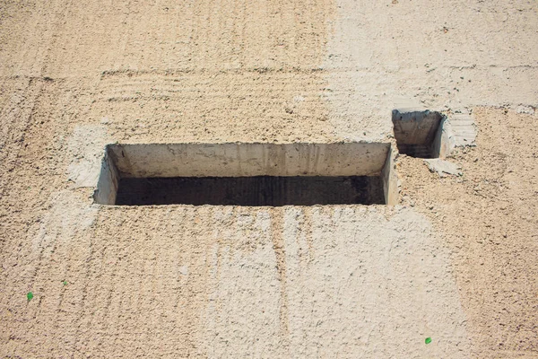 Dikdörtgen delik kanalizasyon ve elektrik kablolama ile çimento duvar — Stok fotoğraf