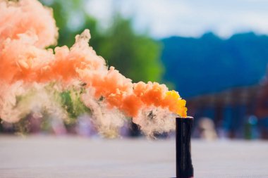 colorful orenge smoke bombs in action clipart