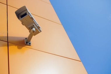 Modern Cctv kamera duvarda. Bulanık gece cityscape arka plan. Gözetim ve izleme kavramı. Tonlu görüntü pozlama sahte katlayın