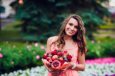 Buket çiçek ve elinde kaba kağıt sarılı taze narenciye