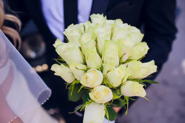 Bouquet de mariage avec des fleurs blanches dans les mains du marié . — Photo