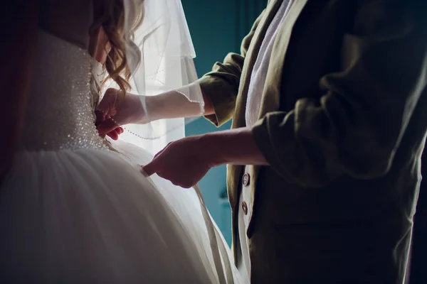Подружка невесты помогает невесте одеться — стоковое фото