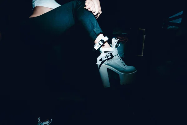 Un piede femminile in scarpe da ginnastica. foto di una ragazza di notte — Foto Stock