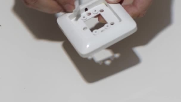 Limpieza a mano de un interruptor de luz de panel plano de cocina blanca con un trapo de polvo de paño de algodón blanco como parte de las tareas regulares de limpieza de la casa . — Vídeo de stock