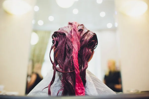Painting red of hair in a beauty salon.