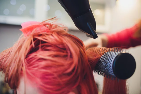 Painting red of hair in a beauty salon.