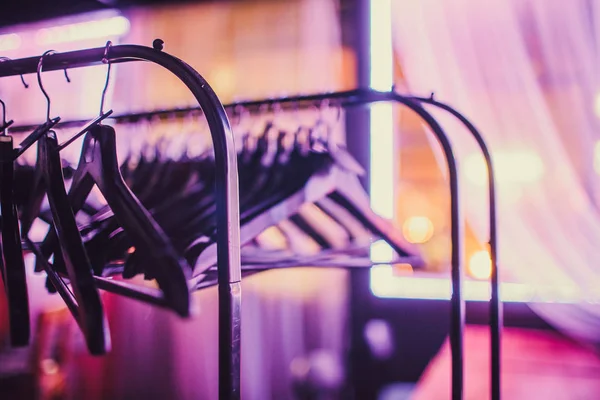 Voorraad van lege kleding hanger in kledingkast, houten kapstokken opknoping op een doek spoor rek in kast hotel slaapkamer. Abstract voor show van pakken shop na uitverkopen. — Stockfoto