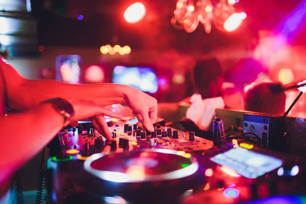 DJ manos en el control remoto. club nocturno. DJ controlando y moviendo los mezcladores en control remoto de música . — Foto de Stock