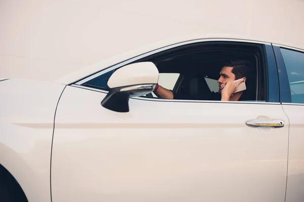 Tiro de un hombre guapo usando el teléfono móvil mientras conduce . —  Fotos de Stock