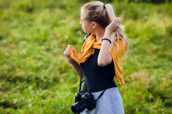 Kobieta fotograf w polu z kamery Robienie zdjęć — Zdjęcie stockowe