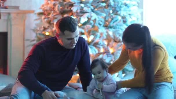 Feliz familia sonriente cerca del árbol de Navidad . — Vídeo de stock