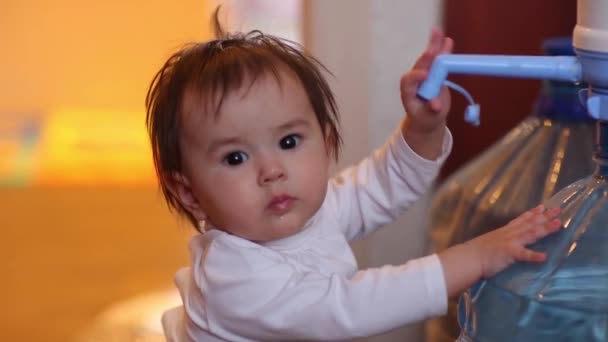 Child baby girl sitting with big bottle of drinking water in diaper and give five open hand sign smiling. — Stock Video