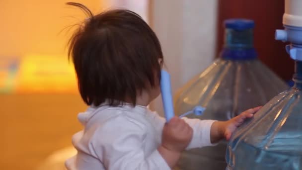 Gyermek kislány ül a nagy üveg ivóvíz pelenka, és adj öt nyitott kéz jele mosolyogva. — Stock videók