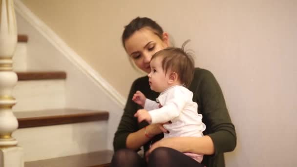 Baby girl smiling in very cute dress sitting on stairs. — Stock Video