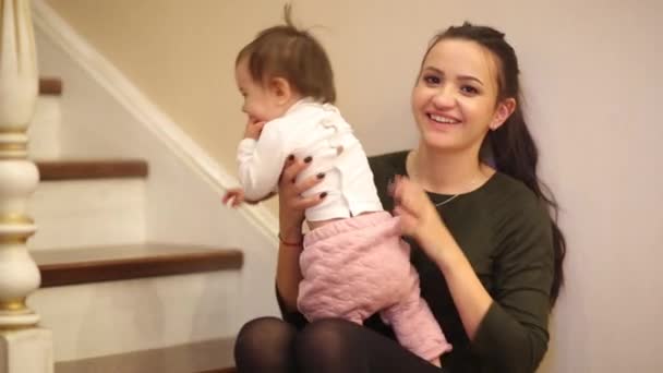 とてもかわいいドレスを着て階段の上に座って笑っている赤ちゃん女の子. — ストック動画