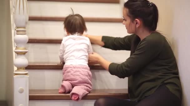 とてもかわいいドレスを着て階段の上に座って笑っている赤ちゃん女の子. — ストック動画