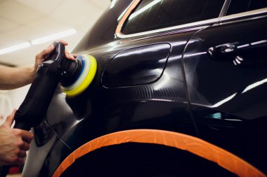 Parlak siyah araba cilalama makinesi bitirmek cilalı. Araba ayrıntılı. Seçici odak.