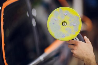 Özel takım elbiseli adam gri araba vücut, araç parlatma araçlık atölye parlatır..