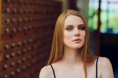 siyah düz saçlı güzel genç kız kutusu ve veri arar Kitaplığı'nda dosya dolabı açar