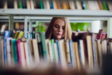 Güzel kız öğrencinin Üniversite Kitaplığı'nda