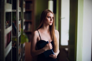 Güzel kız öğrencinin Üniversite Kitaplığı'nda