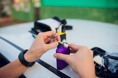 Rebuildable damlama atomizer veya vaping veya e-sigara uzaylı Clapton bobin ve pamuk çizgili için BKİ çıkmak sigara, makro fotoğraf seçici odak ile e-sıvı, modern vape aygıtla birlikte ıslak