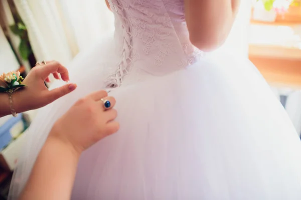 La dama de honor está ayudando a la novia a vestirse —  Fotos de Stock