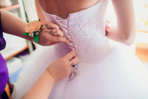 Dama de honra está ajudando noiva a vestir-se — Fotografia de Stock