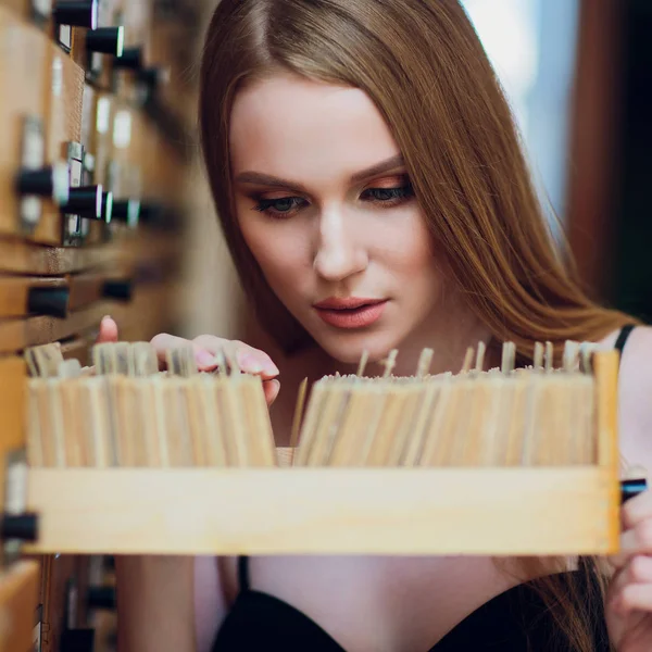 Mooi jong meisje met donkere sluik haar vak en zoekt gegevens geopend in de archiefkast in de bibliotheek — Stockfoto