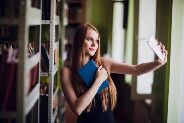 Красивая студентка в библиотеке университета — стоковое фото