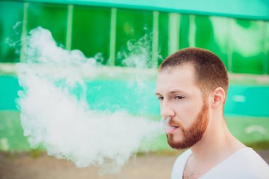 Dostum vaping e-sigara ile e-sıvı, yakın çekim, buhar ya da buhar büyük bulutu nefes. Vape kavramı