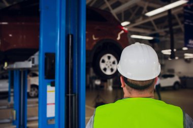 bir araba atölye tekerleğin altına arabayı hizmetindeki çalışmalarında müşteri bakar