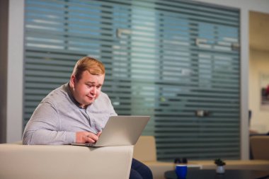 Office çalışma kavramı. Adam ofiste rahat beyaz koltukta oturan onun laptop tarama