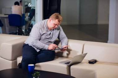 Office çalışma kavramı. Adam ofiste rahat beyaz koltukta oturan onun laptop tarama