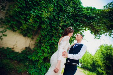 Kısa saç kesimi ve şık bir damat ile gelin parkta yürüyüş.