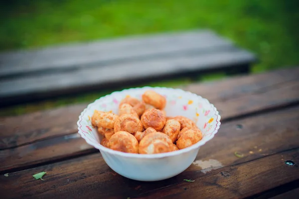 Marinated mushrooms in a bowl on Board. On wooden background. — Stock Photo, Image