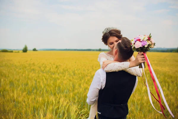Пара жених и невеста на фоне поля . — стоковое фото