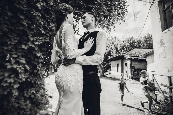 Uma noiva com um corte de cabelo curto e um noivo elegante estão andando no parque preto e branco . — Fotografia de Stock