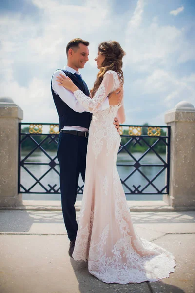 Elegante novia y novio posando en el fondo del río . —  Fotos de Stock