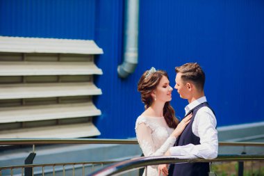 Gelin ve damat yürüyüş şehir, düğün günü, evlilik kavramı. Gelin ve damat kentsel arka planda. Genç çift bir merdivende düğün günü olacak.